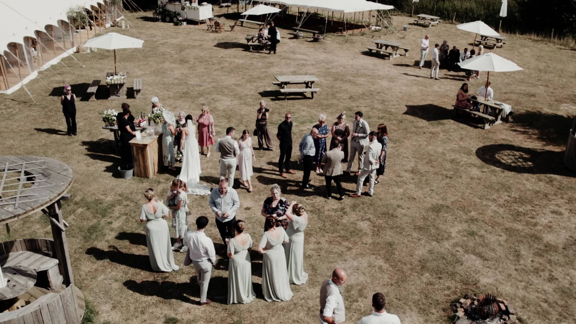 Drone view of the drinks reception at an Ark at Egwood wedding in Somerset, with the bride, guests and marquee